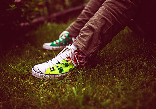 jambes-pieds-assis-herbe-baskets